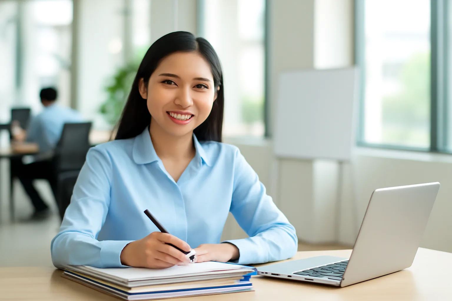 Nhân viên kế toán so sánh thông tin đối tác giữa máy tính xách tay và xấp hồ sơ trên bàn làm việc
